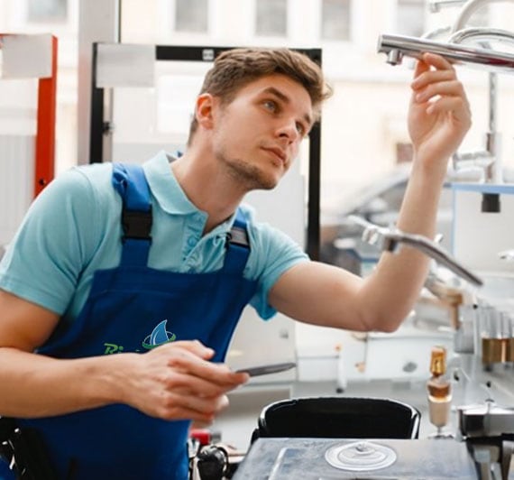 Plumber inspecting a kitchen faucet during residential plumbing service visit in Des Plaines, IL